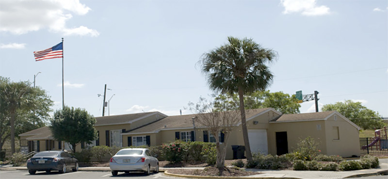 A street view of Griffin Park Apartments with an American flag on a flagpole.