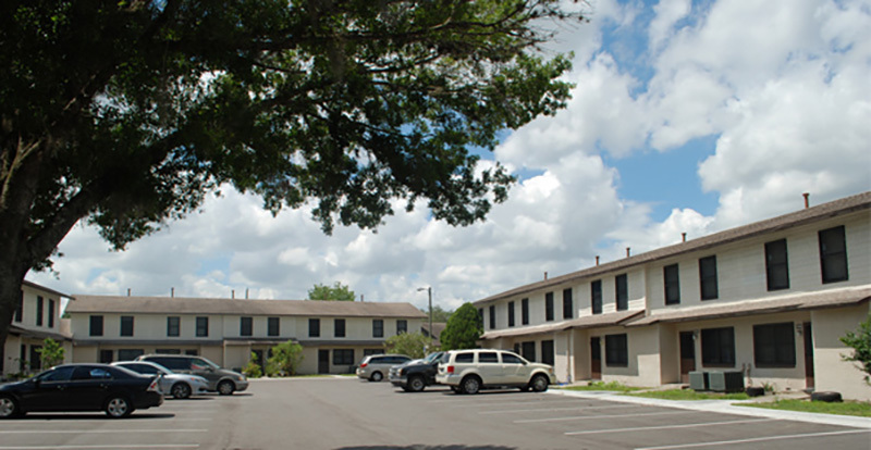 A parking area between long residential buildings at Omega Apartments.