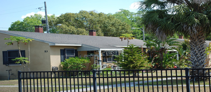 A Reeves Terrace Apartments building surrounded by trees and plants.